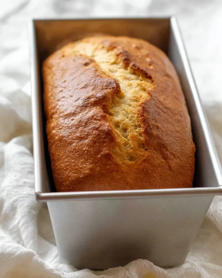 Freshly baked banana bread loaf with slices on a wooden cutting board