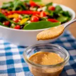 Japanese Deep Roasted Sesame Dressing served on a salad with fresh greens